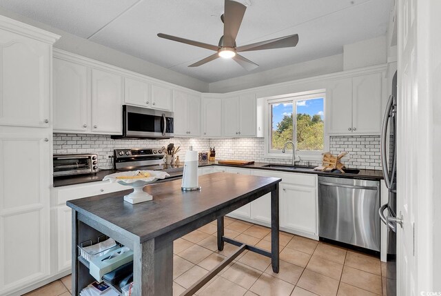 423 Parker Dr Unit 334, Pawleys Island, SC 29585 - kitchen featuring appliances with stainless steel finishes, a sink, dark countertops, and white cabinetry