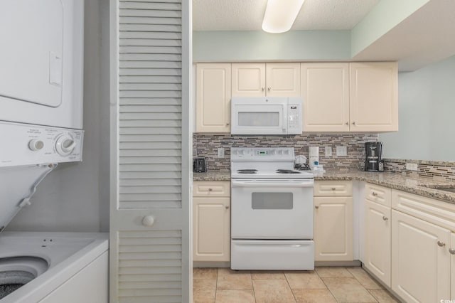201 77th Ave N Unit 1133, Myrtle Beach, SC 29572 - kitchen featuring white appliances, stacked washer and clothes dryer, decorative backsplash, light tile patterned flooring, and light stone countertops
