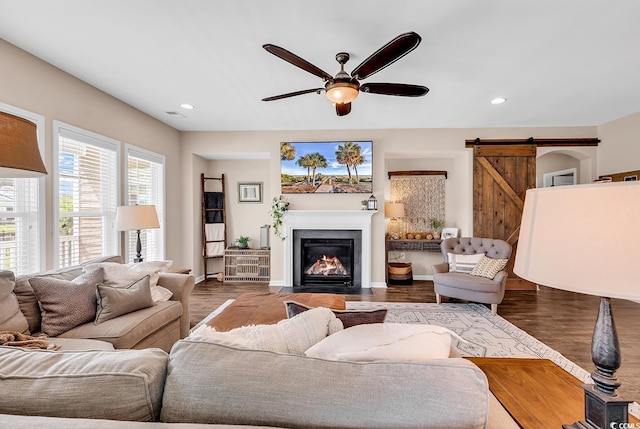 1227 Cypress Shadow Ct, Murrells Inlet, SC 29576 - living room with a barn door, a ceiling fan, a fireplace with flush hearth, recessed lighting, and wood finished floors