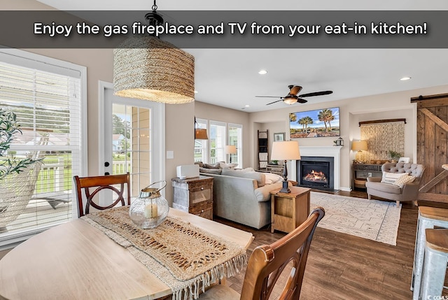 1227 Cypress Shadow Ct, Murrells Inlet, SC 29576 - dining room featuring a barn door, dark wood-style flooring, recessed lighting, ceiling fan, and a fireplace with flush hearth