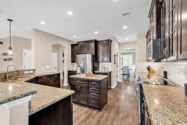 1227 Cypress Shadow Ct, Murrells Inlet, SC 29576 - kitchen featuring arched walkways, appliances with stainless steel finishes, a sink, a center island, and recessed lighting