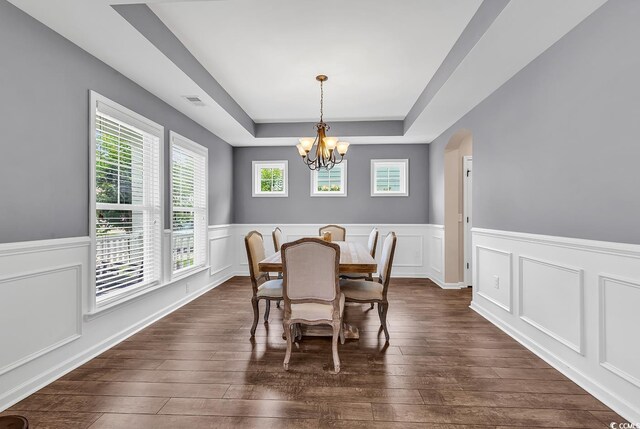 1227 Cypress Shadow Ct, Murrells Inlet, SC 29576 - dining space featuring a raised ceiling, a chandelier, dark wood-type flooring, wainscoting, and a decorative wall
