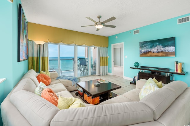 5700 N Ocean Blvd Unit Ph12, North Myrtle Beach, SC 29582 - tiled living area with ceiling fan, a water view, a textured ceiling, and baseboards