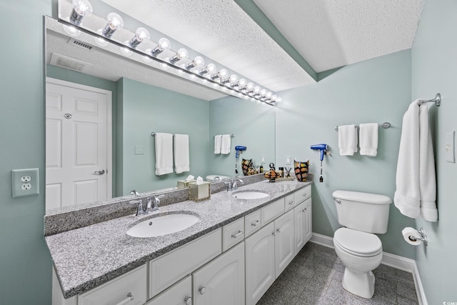 5700 N Ocean Blvd Unit Ph12, North Myrtle Beach, SC 29582 - bathroom featuring double vanity, a textured ceiling, toilet, and baseboards
