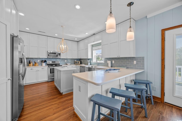 1705 N Ocean Blvd N, North Myrtle Beach, SC 29582 - kitchen with appliances with stainless steel finishes, backsplash, wood finished floors, a peninsula, and recessed lighting