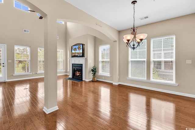 126 Dreamland Dr, Murrells Inlet, SC 29576 - unfurnished living room featuring baseboards, hardwood / wood-style floors, a chandelier, and a glass covered fireplace