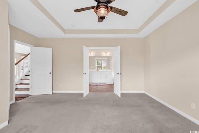 126 Dreamland Dr, Murrells Inlet, SC 29576 - unfurnished bedroom featuring carpet, a tray ceiling, baseboards, ensuite bath, and ceiling fan