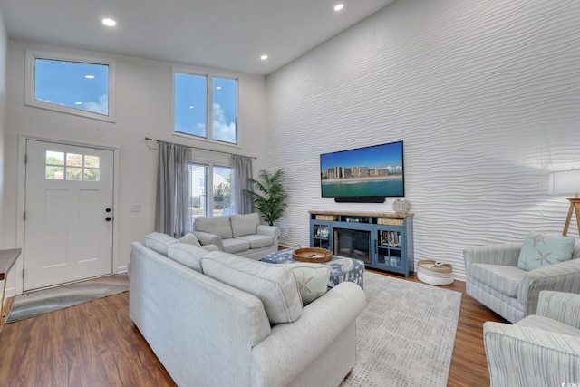 800 S 9th Ave S Unit A-1, North Myrtle Beach, SC 29582 - living room featuring a high ceiling, recessed lighting, plenty of natural light, wood finished floors, and a glass covered fireplace
