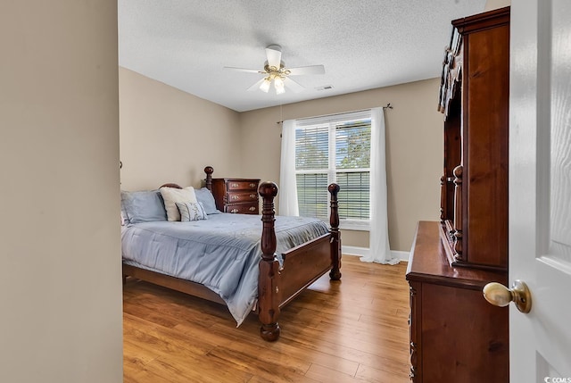 6161 Inman Cir, Conway, SC 29526 - bedroom featuring light wood-type flooring, a textured ceiling, a ceiling fan, and baseboards
