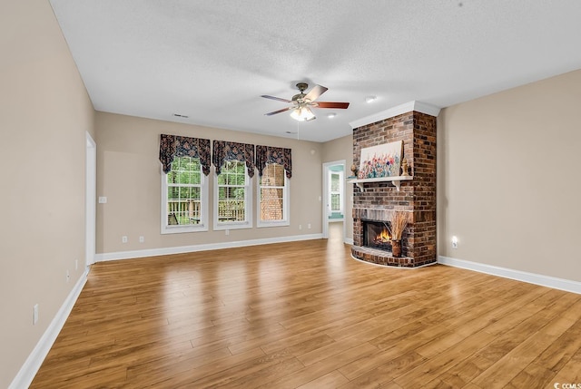 6161 Inman Cir, Conway, SC 29526 - unfurnished living room with a ceiling fan, a fireplace, light wood finished floors, and a textured ceiling