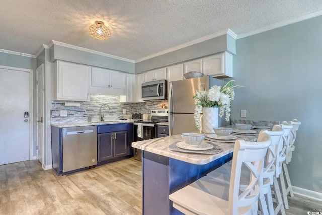 5601 N Ocean Blvd Unit A-307, Myrtle Beach, SC 29577 - kitchen with stainless steel appliances, white cabinetry, crown molding, light wood finished floors, and a textured ceiling