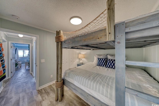 5601 N Ocean Blvd Unit A-307, Myrtle Beach, SC 29577 - bedroom featuring wood finished floors, a textured ceiling, crown molding, and baseboards