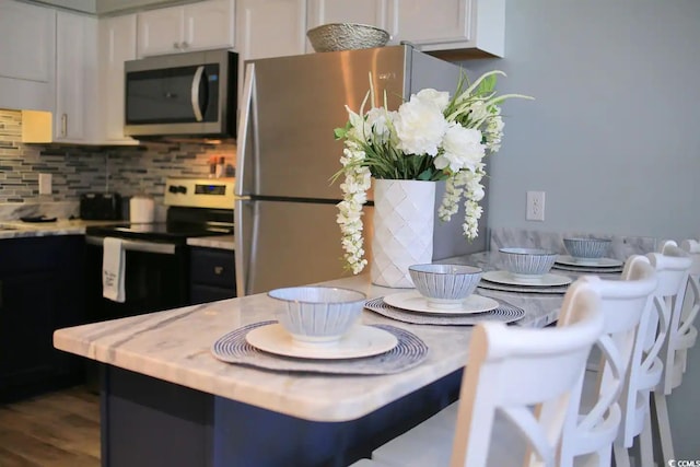 5601 N Ocean Blvd Unit A-307, Myrtle Beach, SC 29577 - kitchen with stainless steel appliances, light countertops, white cabinetry, decorative backsplash, and dark wood-style flooring