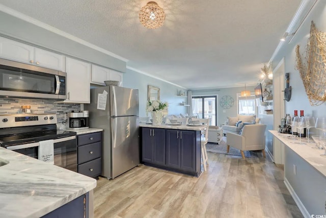5601 N Ocean Blvd Unit A-307, Myrtle Beach, SC 29577 - kitchen with appliances with stainless steel finishes, white cabinets, open floor plan, light wood-type flooring, and ornamental molding