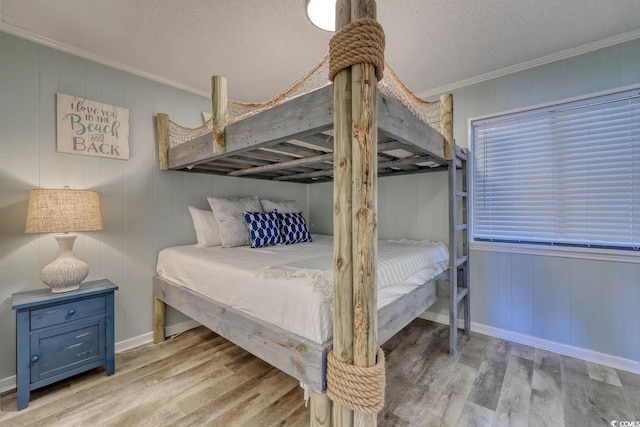 5601 N Ocean Blvd Unit A-307, Myrtle Beach, SC 29577 - bedroom featuring wood finished floors, ornamental molding, a textured ceiling, wooden walls, and baseboards