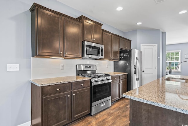 4115 Alvina Way, Myrtle Beach, SC 29579 - kitchen with appliances with stainless steel finishes, a sink, dark wood-type flooring, dark brown cabinets, and light stone countertops
