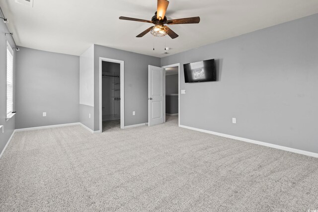 4115 Alvina Way, Myrtle Beach, SC 29579 - unfurnished bedroom with a walk in closet, baseboards, light colored carpet, and a ceiling fan