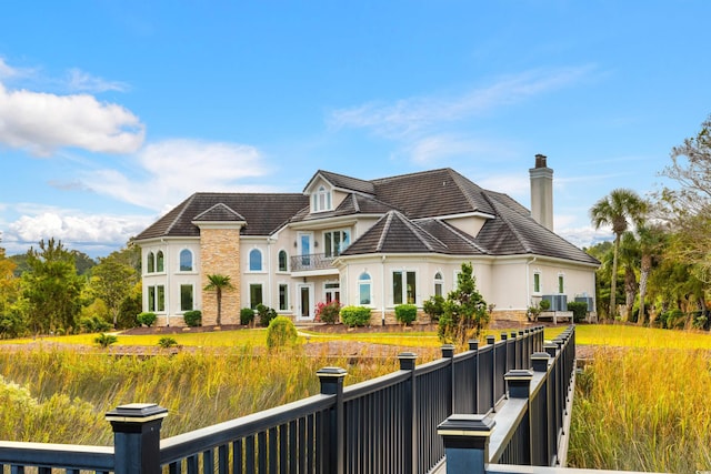 2715 Ships Wheel Dr, North Myrtle Beach, SC 29582 - rear view of property featuring stucco siding, a chimney, a balcony, and stone siding