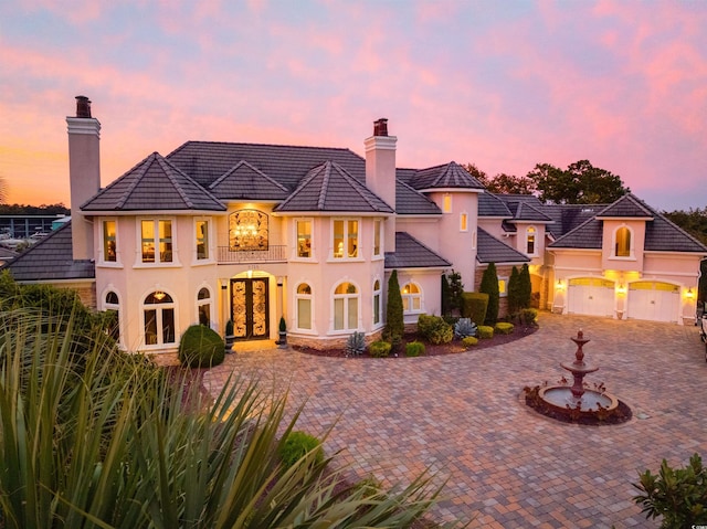 2715 Ships Wheel Dr, North Myrtle Beach, SC 29582 - view of front of house with stucco siding, a chimney, curved driveway, and french doors
