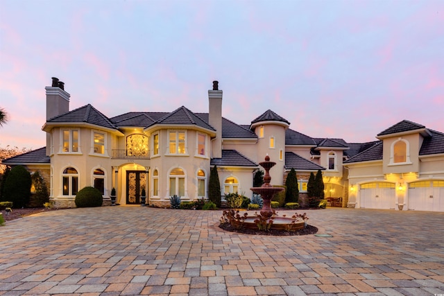 2715 Ships Wheel Dr, North Myrtle Beach, SC 29582 - french provincial home featuring french doors, curved driveway, stucco siding, an attached garage, and a chimney