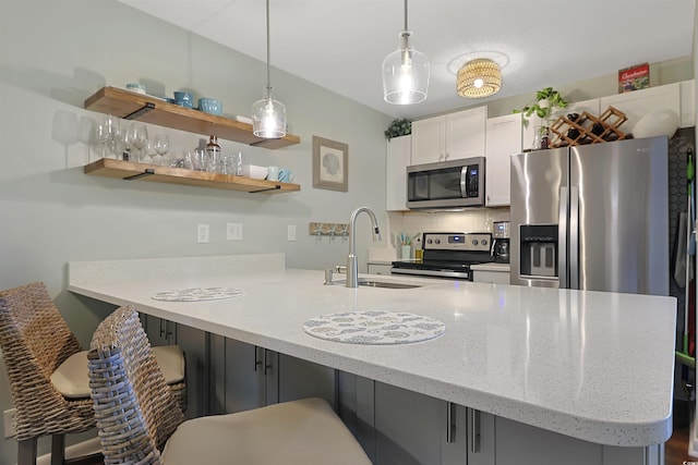 88 Salt Marsh Cir Unit 22F, Pawleys Island, SC 29585 - kitchen featuring stainless steel appliances, a sink, a peninsula, tasteful backsplash, and a kitchen breakfast bar