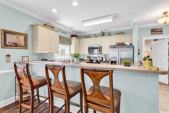 4820 Magnolia Lake Dr Unit 305, Myrtle Beach, SC 29577 - kitchen with stainless steel appliances, a breakfast bar area, ornamental molding, a peninsula, and recessed lighting