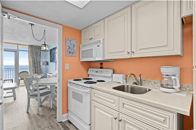 2801 S Ocean Blvd Unit 835, North Myrtle Beach, SC 29582 - kitchen featuring white appliances, light wood-type flooring, light countertops, a water view, and expansive windows