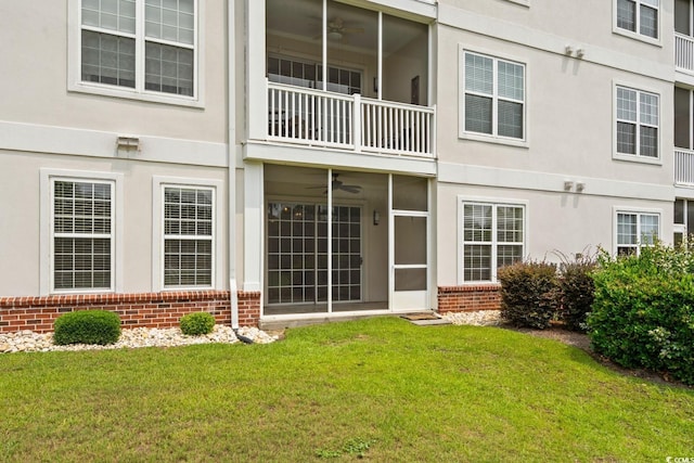 2241 Waterview Dr Unit 514, North Myrtle Beach, SC 29582 - back of property featuring brick siding, a balcony, a lawn, a ceiling fan, and stucco siding