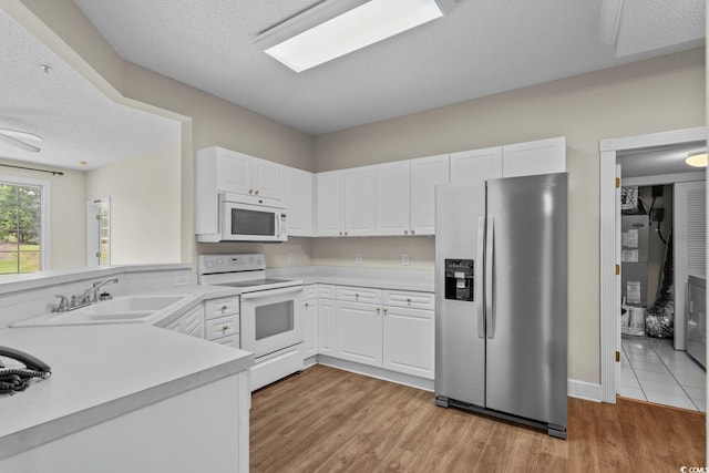2241 Waterview Dr Unit 514, North Myrtle Beach, SC 29582 - kitchen featuring white appliances, a sink, light countertops, white cabinetry, and a textured ceiling