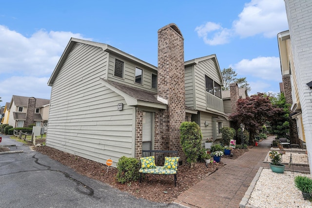 705 11th Ave S, North Myrtle Beach, SC 29582 - view of side of property featuring a chimney and a shingled roof