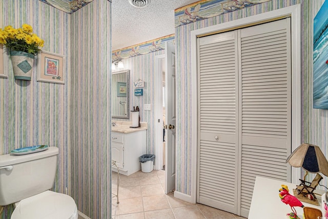 705 11th Ave S, North Myrtle Beach, SC 29582 - bathroom featuring wallpapered walls, tile patterned floors, a closet, vanity, and a textured ceiling