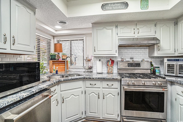 705 11th Ave S, North Myrtle Beach, SC 29582 - kitchen featuring stainless steel appliances, under cabinet range hood, a sink, decorative backsplash, and white cabinets