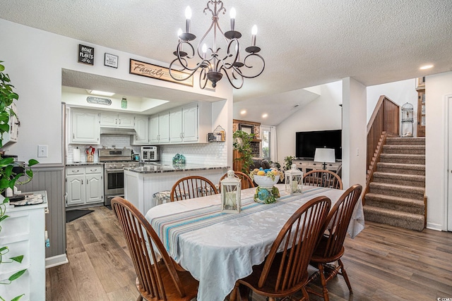 705 11th Ave S, North Myrtle Beach, SC 29582 - dining area featuring wood finished floors, a textured ceiling, a chandelier, stairs, and a wainscoted wall