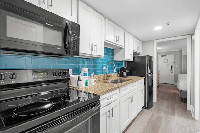 7200 N Ocean Blvd Unit 260, Myrtle Beach, SC 29572 - kitchen featuring black appliances, white cabinets, light wood finished floors, light stone countertops, and decorative backsplash