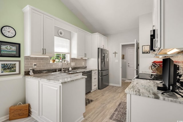 168 Mackinley Cir, Pawleys Island, SC 29585 - kitchen with appliances with stainless steel finishes, white cabinets, decorative backsplash, light wood-style floors, and vaulted ceiling