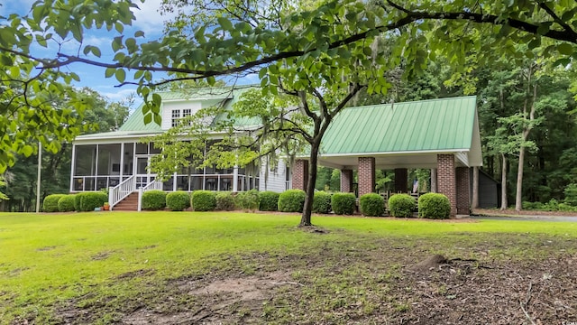 3231 Center Rd, Georgetown, SC 29440 - view of front facade with a sunroom, brick siding, a front lawn, and metal roof