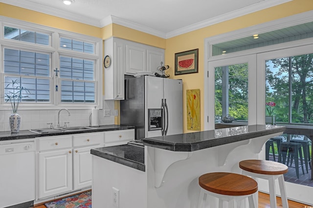 3231 Center Rd, Georgetown, SC 29440 - kitchen with dishwasher, stainless steel fridge, a breakfast bar, healthy amount of natural light, and ornamental molding