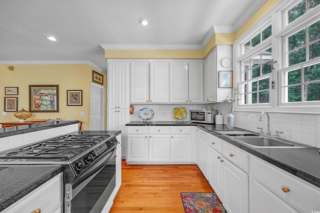 3231 Center Rd, Georgetown, SC 29440 - kitchen featuring white appliances, a sink, dark countertops, ornamental molding, and white cabinetry
