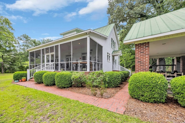 3231 Center Rd, Georgetown, SC 29440 - view of side of property featuring a sunroom, a lawn, and metal roof