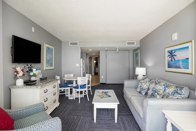 300 N Ocean Blvd Unit 723, North Myrtle Beach, SC 29582 - living room featuring a textured ceiling and dark carpet