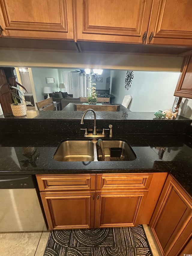 201 Hillside Dr N Unit 111, North Myrtle Beach, SC 29582 - kitchen featuring stainless steel dishwasher, a sink, light tile patterned floors, brown cabinetry, and dark stone counters