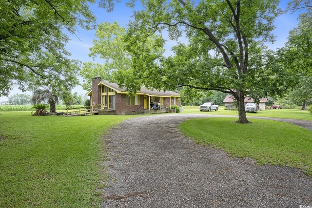 1731 Lee Ln, Longs, SC 29568 - view of front facade featuring curved driveway, a front lawn, a chimney, and brick siding