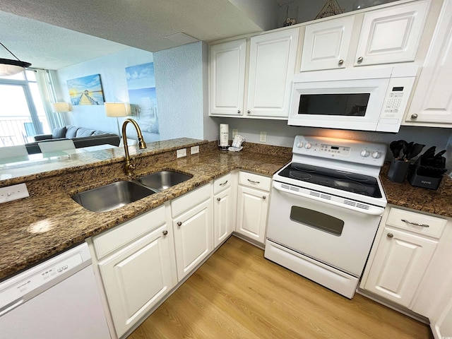 2007 S Ocean Blvd Unit 1506, Myrtle Beach, SC 29577 - kitchen with white appliances, a sink, light wood-style flooring, white cabinets, and dark stone counters