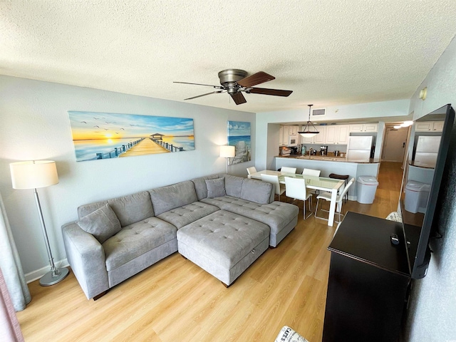 2007 S Ocean Blvd Unit 1506, Myrtle Beach, SC 29577 - living room with a textured ceiling, ceiling fan, and light wood finished floors