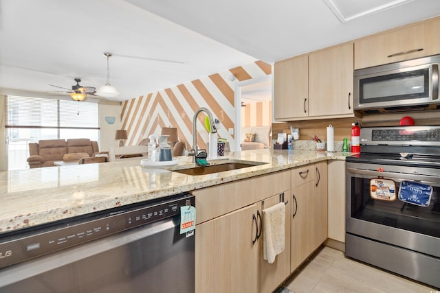 9820 Queensway Blvd Unit 502, Myrtle Beach, SC 29572 - kitchen featuring stainless steel appliances, light brown cabinets, a sink, wallpapered walls, and light stone counters