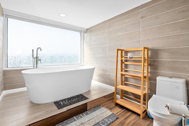 9820 Queensway Blvd Unit 502, Myrtle Beach, SC 29572 - bathroom featuring a freestanding bath, toilet, wood finished floors, tile walls, and recessed lighting