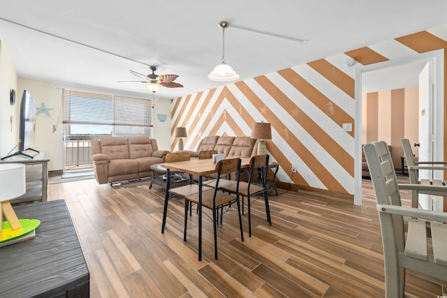 9820 Queensway Blvd Unit 502, Myrtle Beach, SC 29572 - dining room with wallpapered walls, an accent wall, ceiling fan, wood finished floors, and baseboards