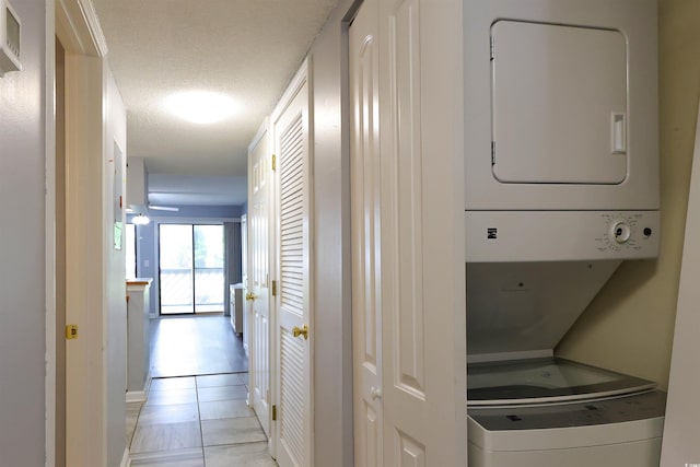 1100 Possum Trot Dr Unit D106, North Myrtle Beach, SC 29582 - laundry room with estacked washer and dryer, light tile patterned floors, and a textured ceiling