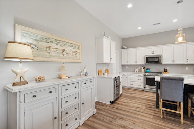 314 Bumble Cir, Murrells Inlet, SC 29576 - kitchen featuring stainless steel appliances, wine cooler, white cabinets, light wood-style flooring, and decorative backsplash
