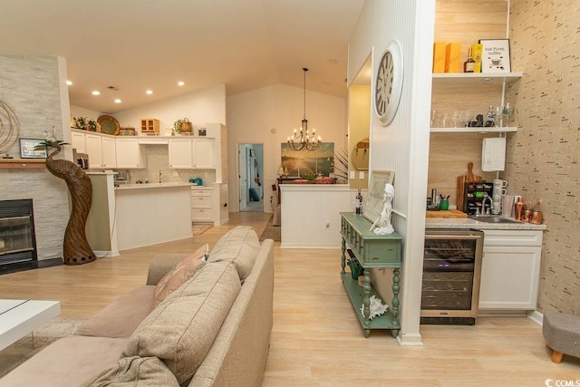 108 Pipers Ln Unit 108, Myrtle Beach, SC 29575 - living area with wine cooler, vaulted ceiling, light wood-type flooring, a chandelier, and a fireplace